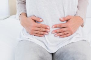 woman holding her bloated stomach