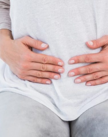 woman holding her bloated stomach