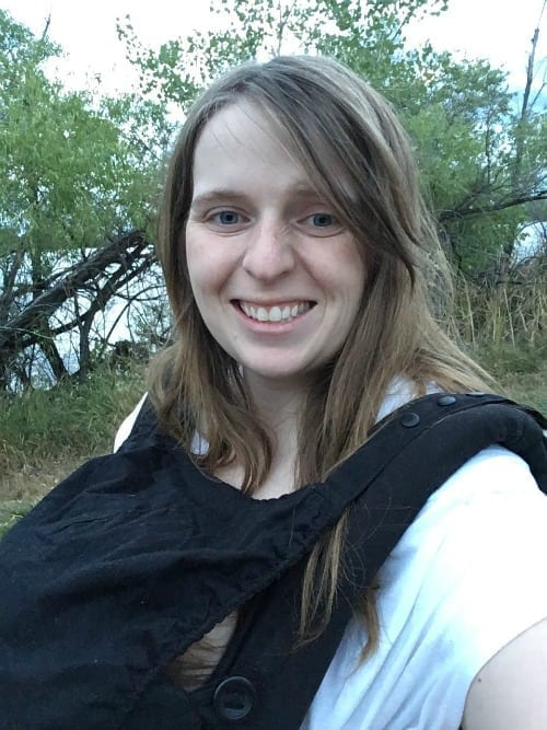 Breastfeeding newborn in ergo baby carrier top