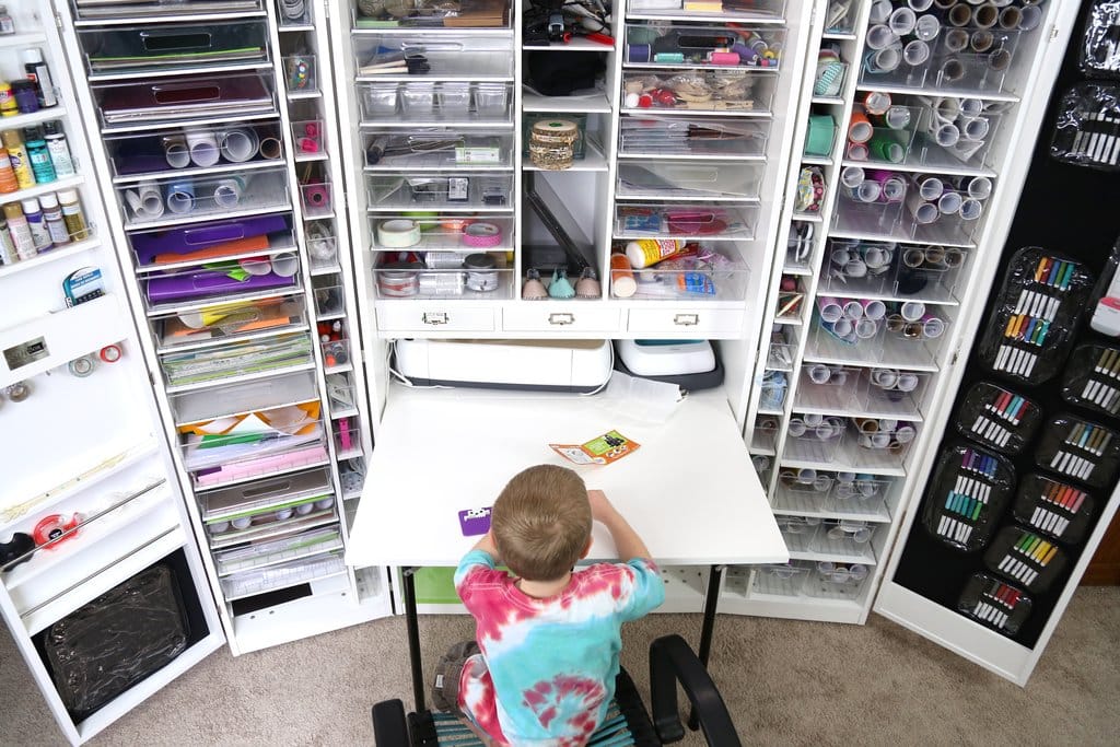 Child back facing the camera, sitting beside a desk