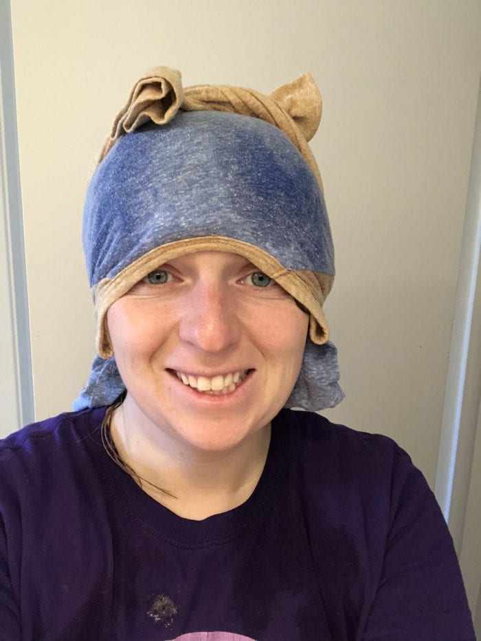 A person wearing a towel hat and smiling at the camera, with Curly Girl Method