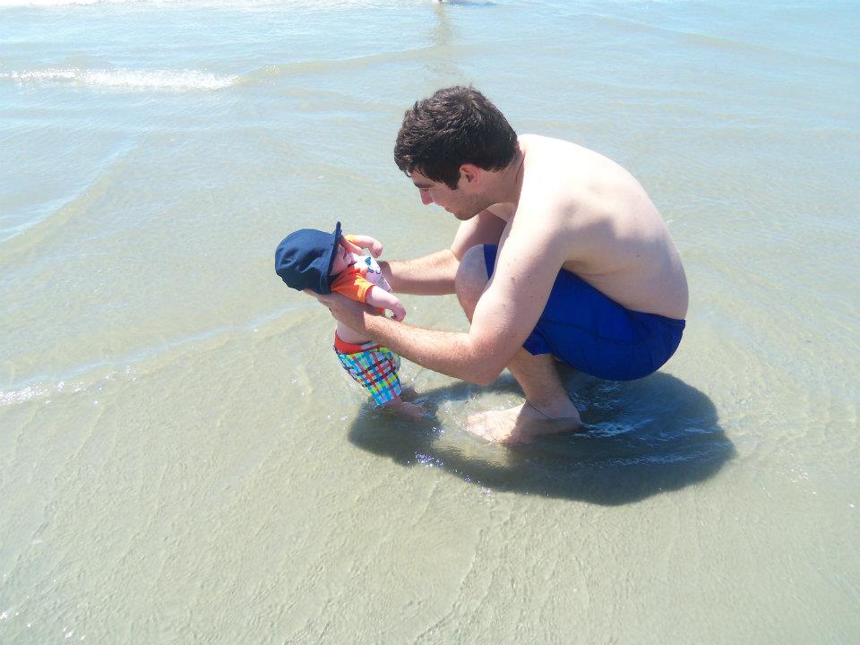Man holding a baby on beach