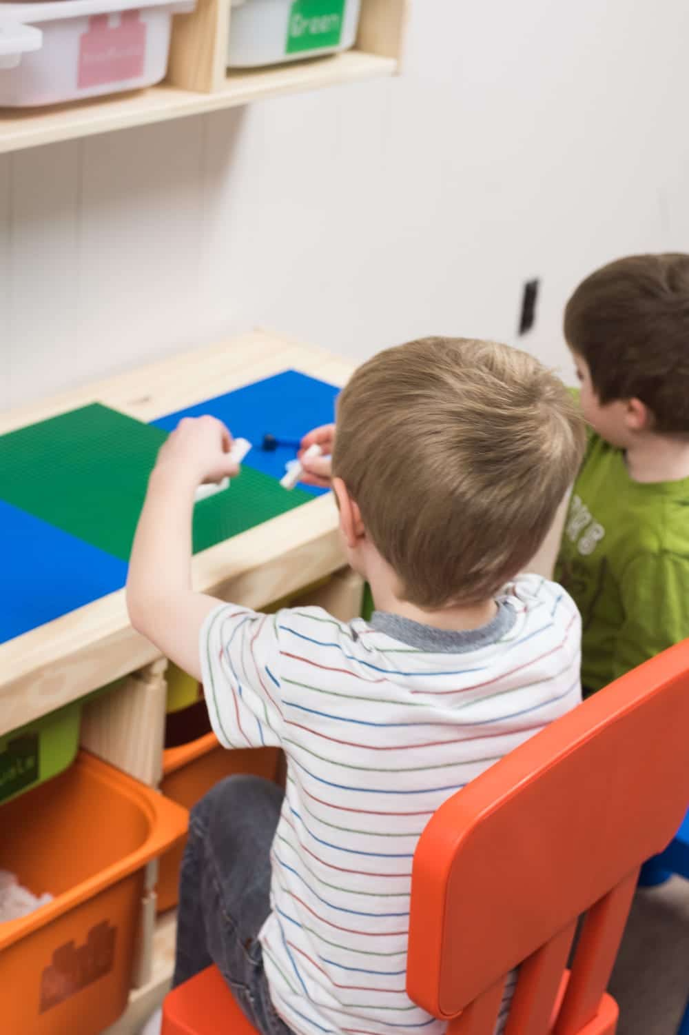 child sitting at lego table