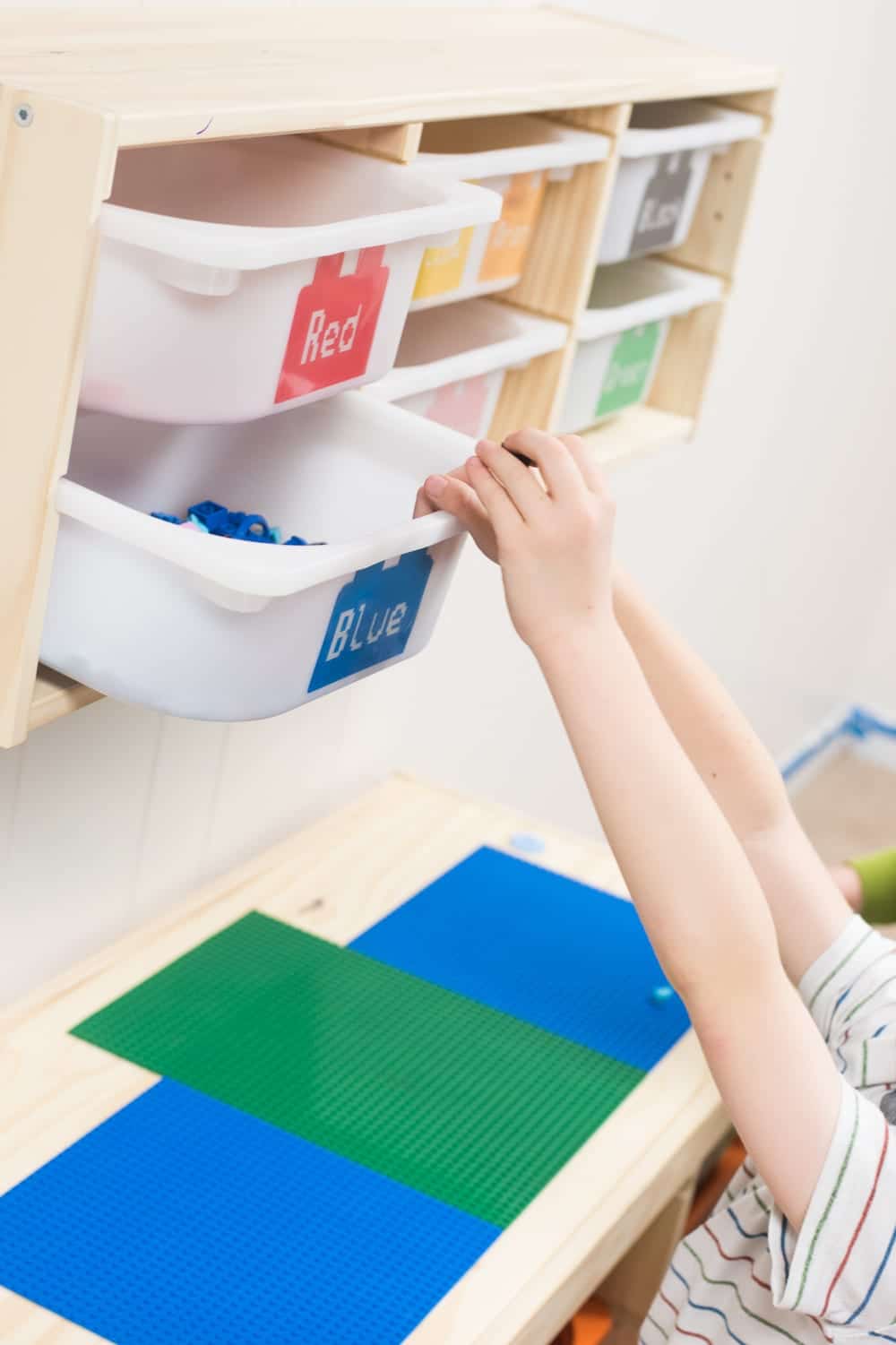 Child reaching for lego bin