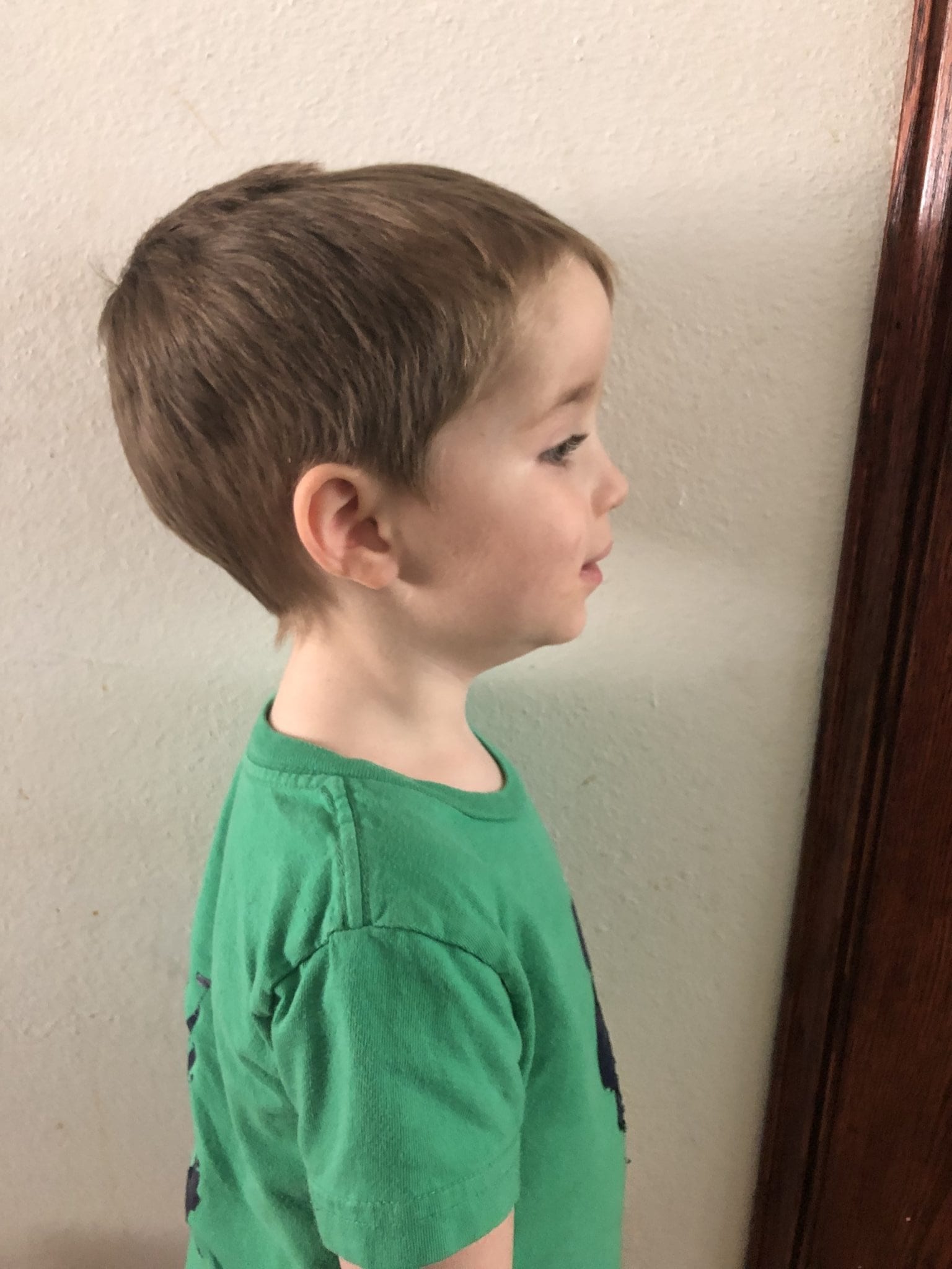 little boy standing by wall