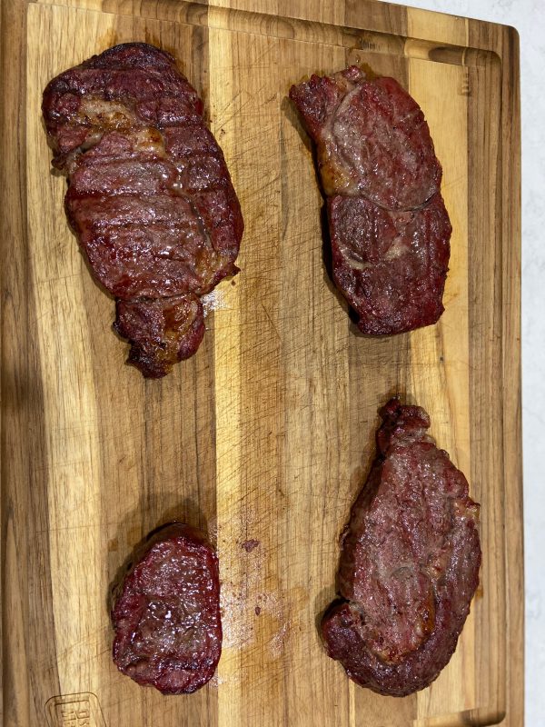 Food on a wooden cutting board, with Steak and Beef