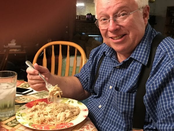 A man sitting at a table with a plate of food