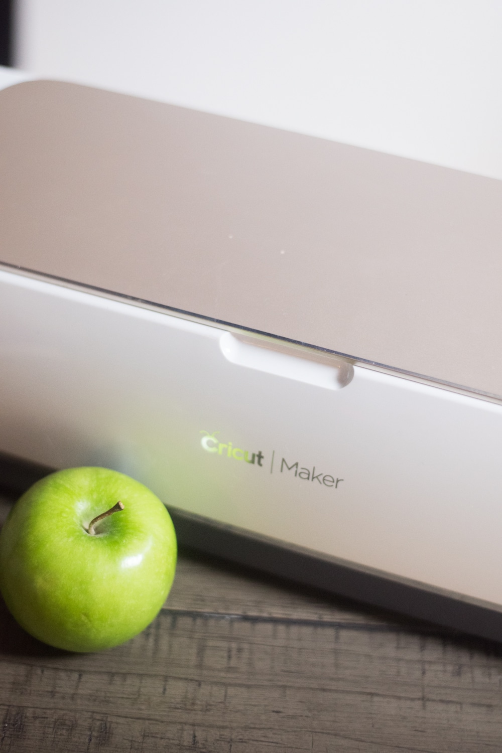 A green apple in front of cricut maker