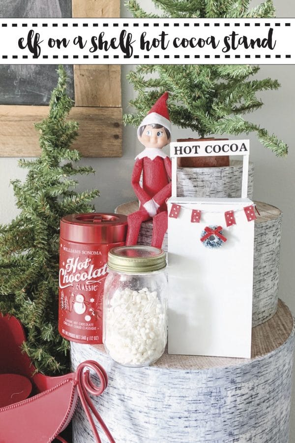 Elf sitting near a hot cocoa stand