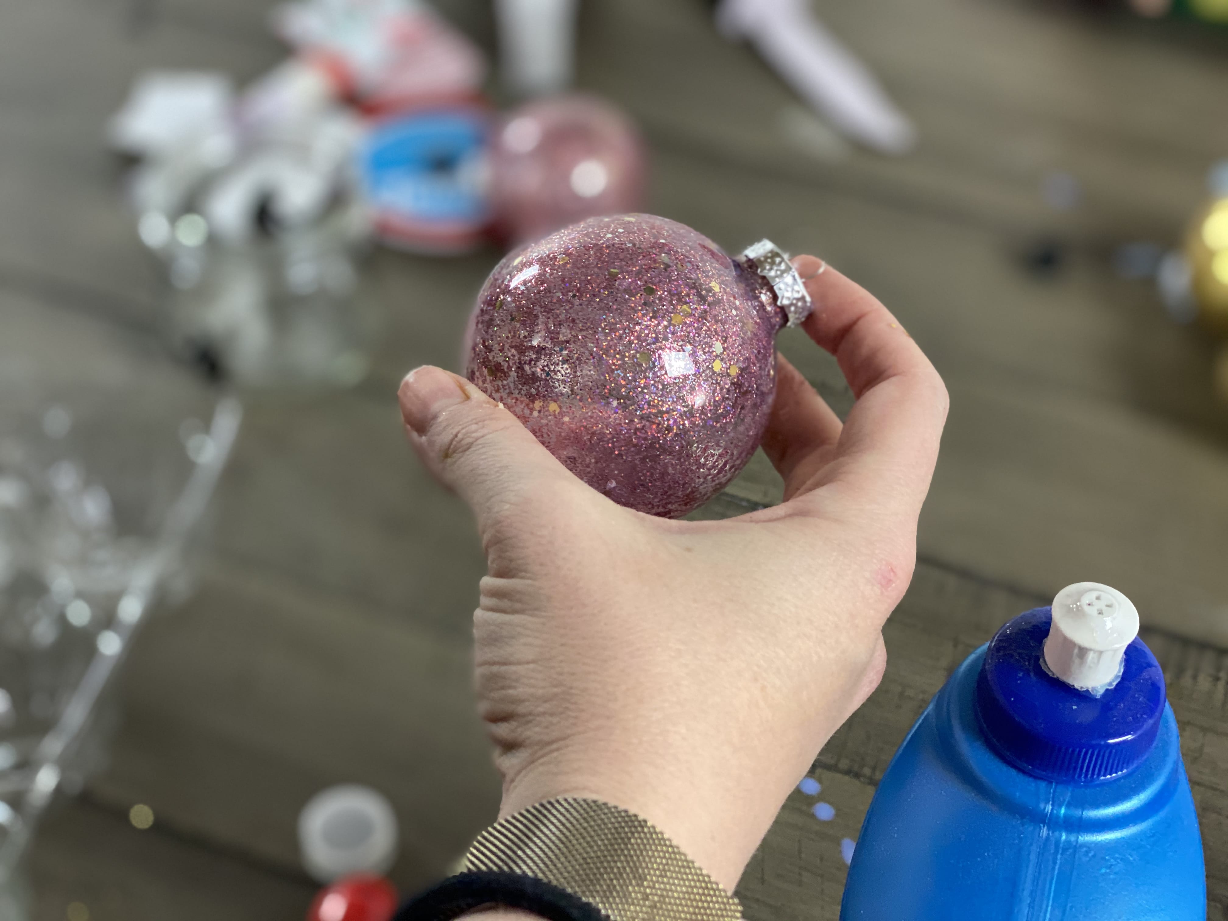 glitter ornament with hand holding it