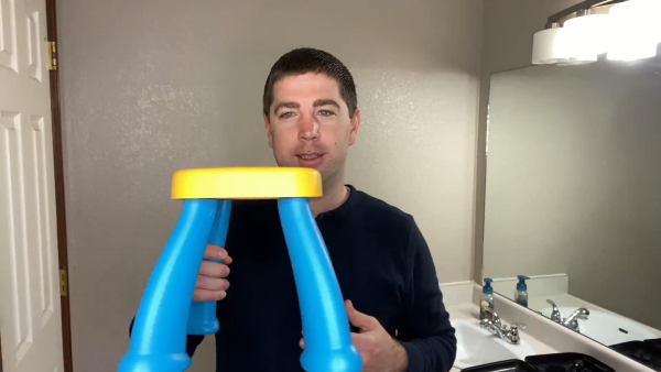 A man brushing his teeth in front of a mirror posing for the camera