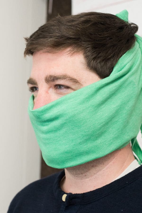 A close up of a man wearing t shirt face mask