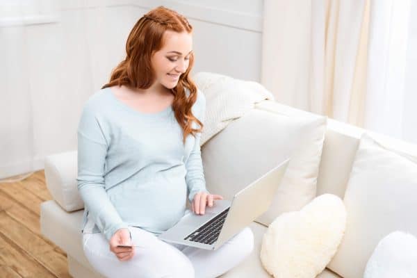 woman sitting on a computer while pregnant 