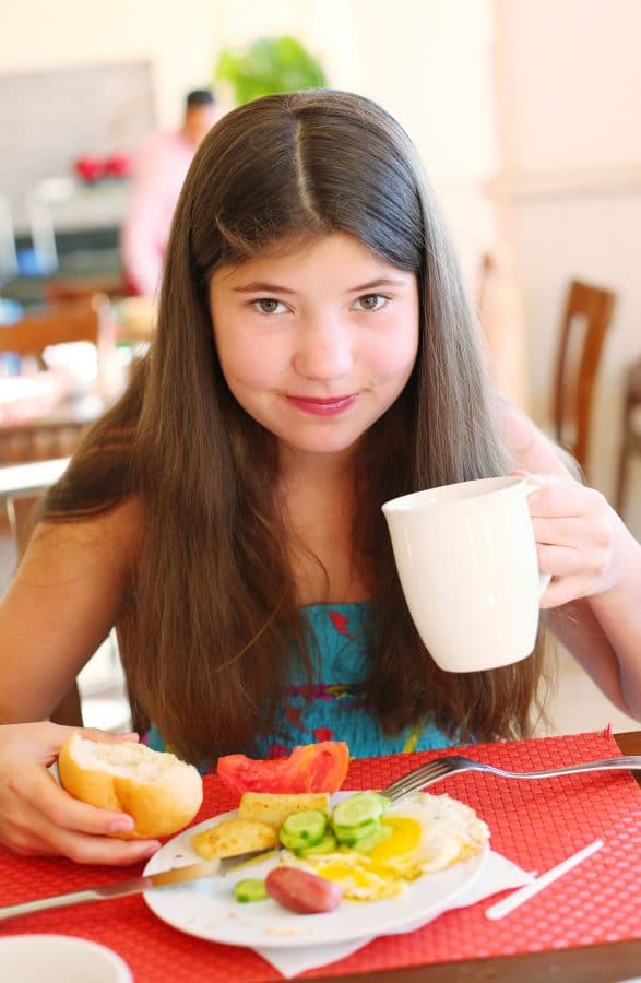 A woman sitting at a table with a plate of food, with Buffet