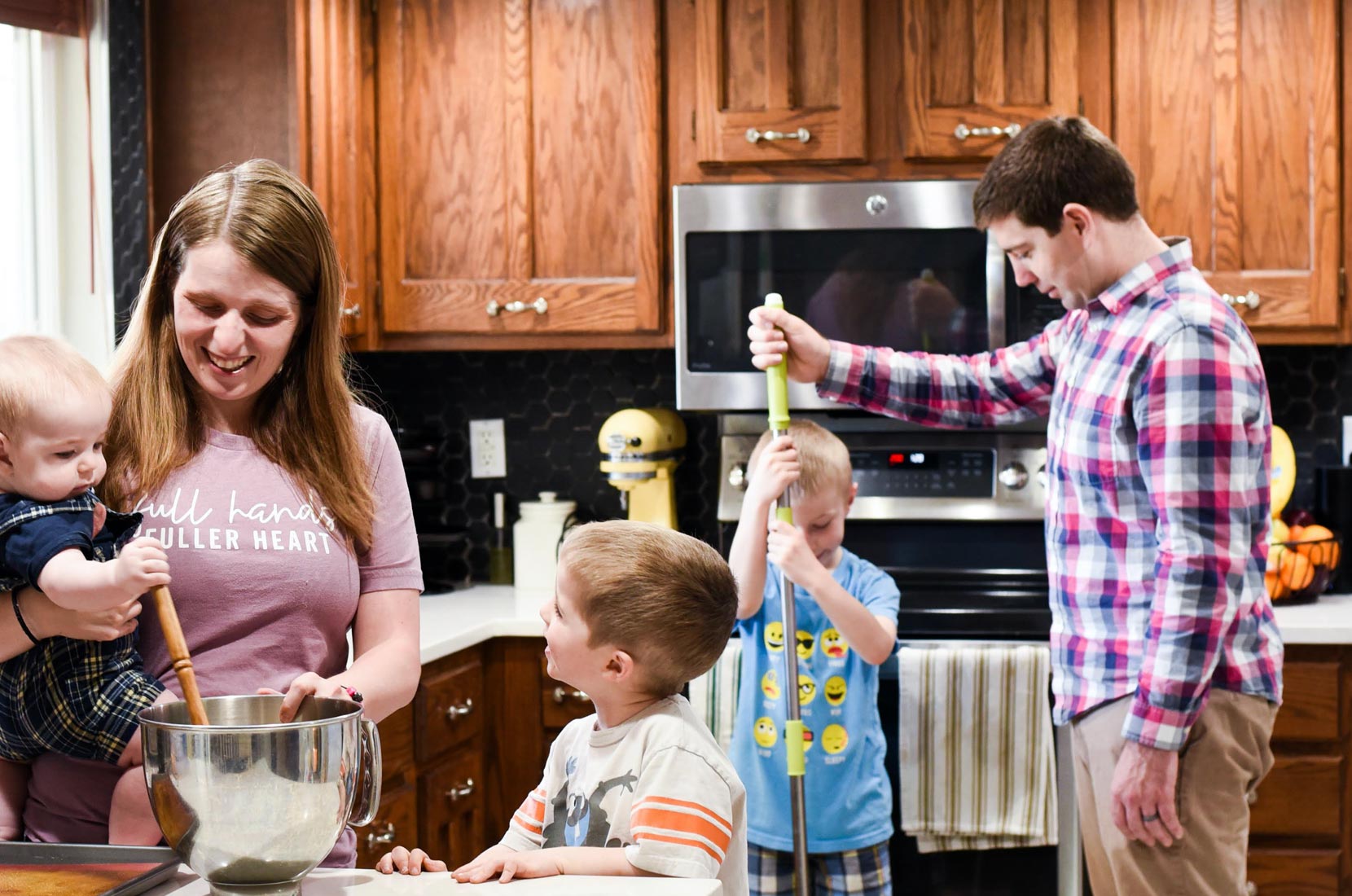 A couple of people that are standing in the kitchen