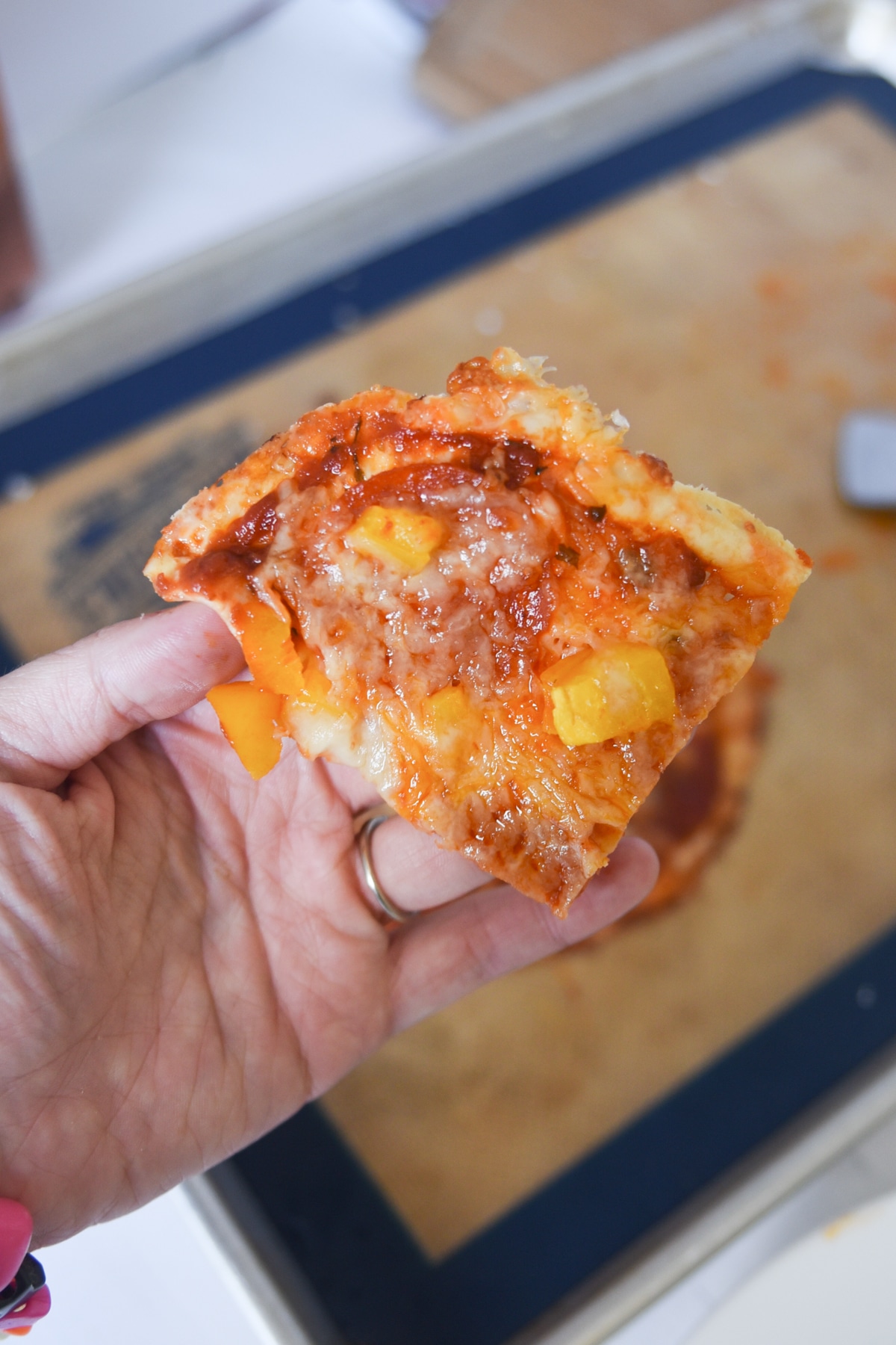 Easy Keto Pizza Crust made with Crystal Farms Cheese. This photo shows a slice of pizza with pepperoni and yellow peppers. 