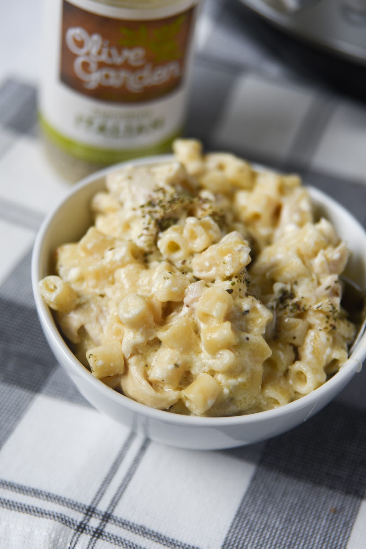 chicken pasta in white bowl with olive garden dressing