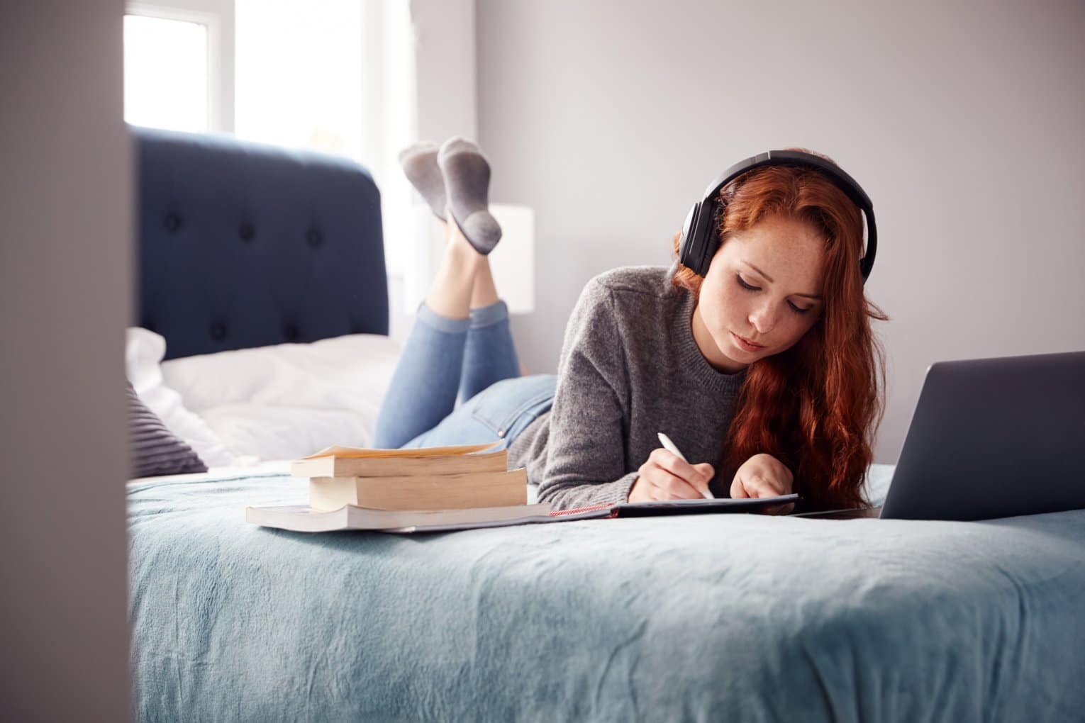 student wearing headphones while doing homework