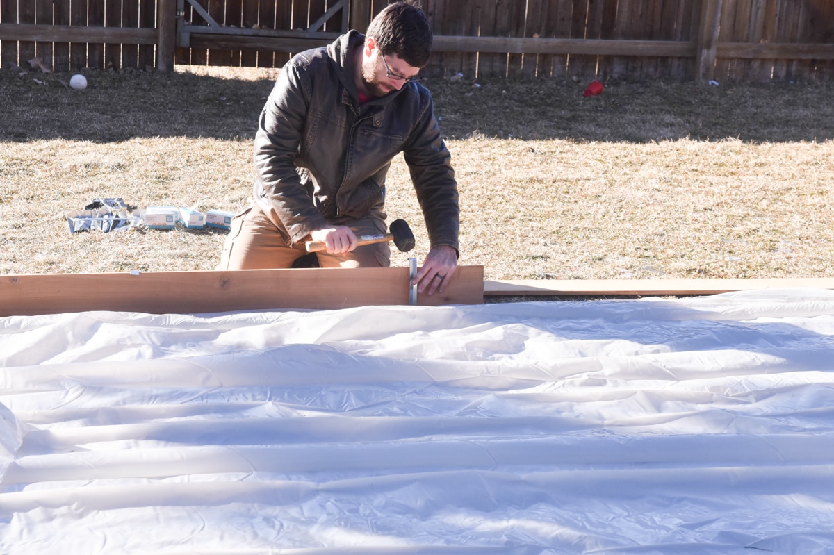 hammering stakes into ground