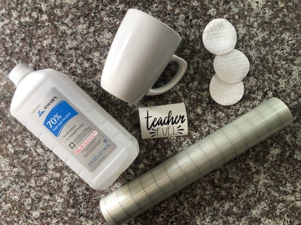 supplies: mug, vinyl design, transfer tape, rubbing alcohol, and cotton rounds