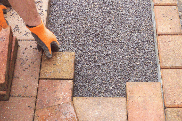 person placing pavers on ground
