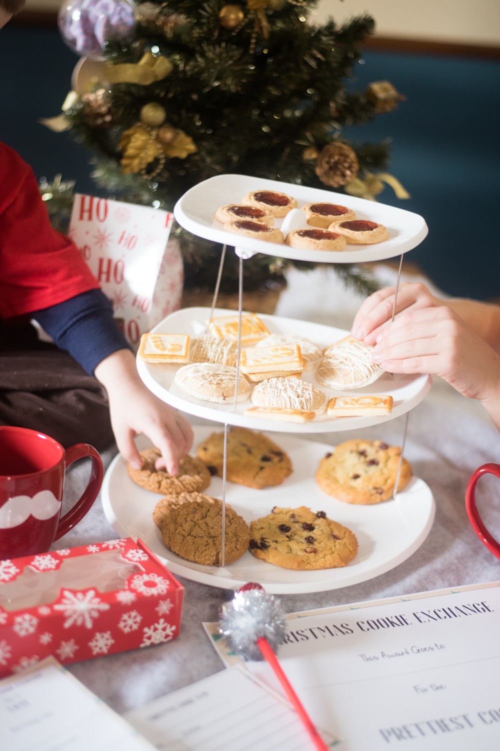 A woman sitting at a table with a plate of food, with Christmas cookie